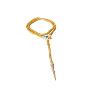 Luxurious gold snake-shaped tassel necklace with sparkling diamonds and a green emerald eye