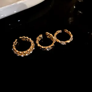 Dettaglio ravvicinato di tre lussuosi anelli placcati in oro con strass scintillanti