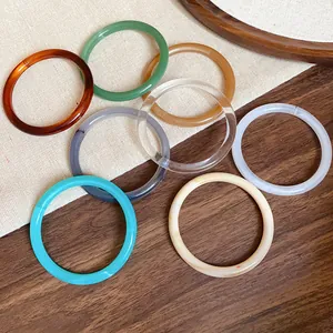 Selection of colorful retro acrylic and acetate bangles on a rustic wooden background