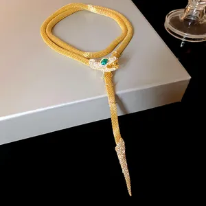 Elegant gold snake necklace with sparkling crystals and green gemstone eye detail