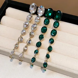 Elegante funkelnde Quastenohrringe mit klaren und smaragdgrünen ovalen Steinen