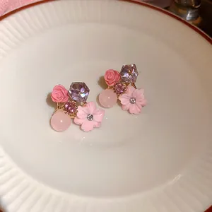 Gedetailleerd beeld van zoete roze bloemoorbellen met roos- en kersenbloesem op een bordje