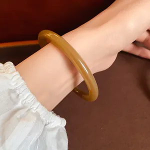 Close-up view of a retro honey-colored translucent acrylic acetate bangle on wrist