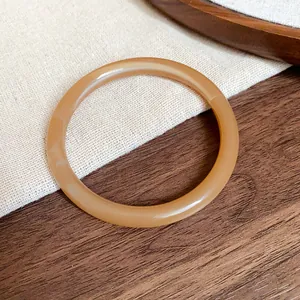 Detailed macro shot of amber acetate bangle showcasing smooth texture and marble pattern