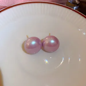 Close-up van paarse parelmoerachtige bolvormige oorknopjes met elegante glans