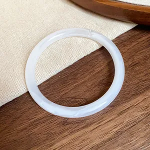 Macro detail of a vintage off-white acrylic acetate bangle with cloudy marble texture.