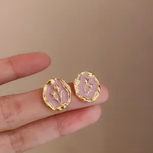 Detail van de roze tulp emaille oorknopjes met een gouden rand en kleine parels.