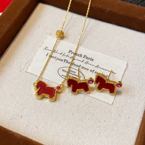 Close-up of vintage gold red horse necklace and earrings set with zircon stones