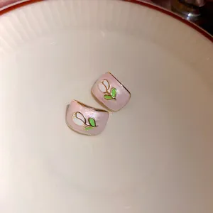 Detailweergave van zoete roze tulp oorbellen met parelmoer afwerking en gouden randje