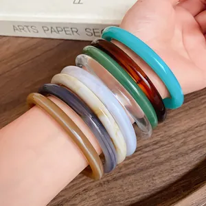 Close-up of stacked colorful acrylic acetate geometric bangles in a vintage design