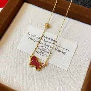 Detailed shot of a vintage gold zircon necklace with a red horse pendant in a gift box.