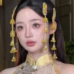 Gros plan de pinces à cheveux ethniques dorées à glands et cloches avec strass.