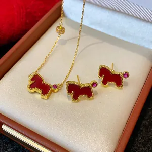 Detailed view of red pony jewelry set featuring a gold necklace and stud earrings in box
