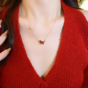 Close-up of a gold clavicle chain featuring a vibrant red horse pendant for women