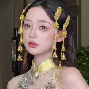Vue détaillée des pinces à cheveux dorées de style ethnique avec fleurs et clochettes