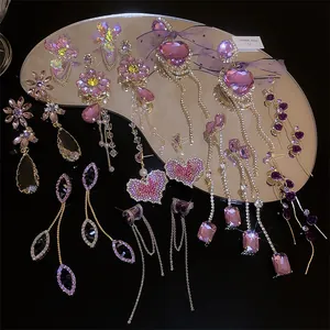 Collection of elegant purple rhinestone earrings with floral and heart-shaped tassel designs