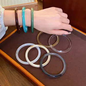 Selection of retro acrylic acetate bangles in various colors displayed on a tray