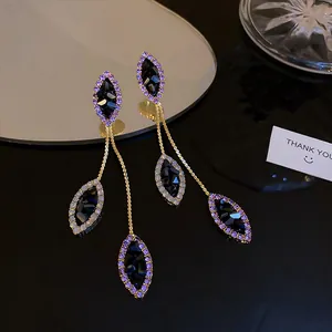 Close-up of purple rhinestone tassel earrings with black faceted marquise stones