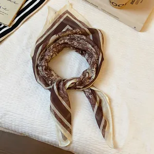 Detailed macro view of a vintage brown paisley print lightweight silk neck scarf.