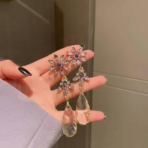 Exquisite detail of purple floral dangling earrings with clear teardrop crystal.