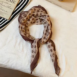 Detailed close-up view of a vintage brown floral printed silk-like scarf neckpiece.