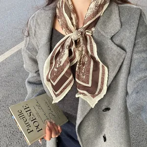 Close-up detail of a vintage paisley print neck scarf styled on a grey wool coat