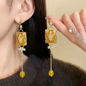 Detail shot of vintage gold earrings with faux pearls and embossed flower pattern