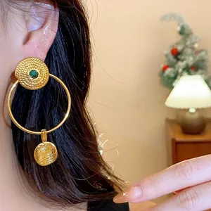 Vintage gold plated hoop earrings with textured round pendants and green stone accent.
