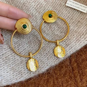 Vintage gold-plated hoop earrings with textured dangles and green stones.