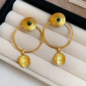 Vintage gold plated hoop earrings featuring intricate circular textures and green stones