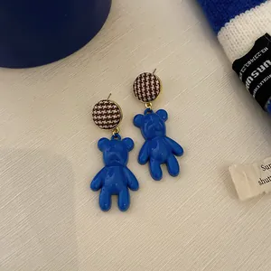 Detail view of Klein Blue bear drop earrings with a stylish houndstooth circular stud top