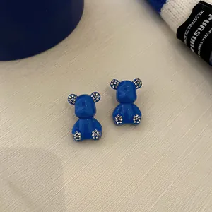 Detailed macro view of Klein blue bear stud earrings featuring sparkly rhinestones