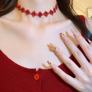 Detailed close-up of red handmade flower beaded choker necklace on model.