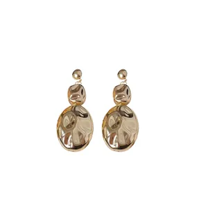 Elegant gold hammered oval drop earrings with a minimalist crumpled metal texture finish