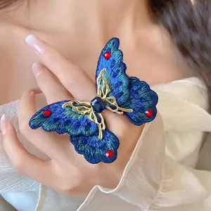 Elegante anello aperto a farfalla lavorato a maglia con strass blu e rossi scintillanti
