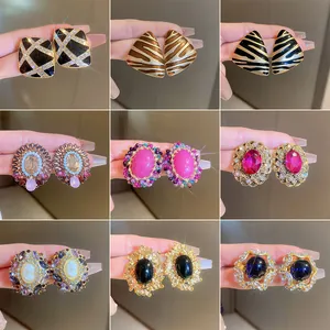 Detailed view of nine pairs of vintage-style earrings with colorful crystals and patterns.