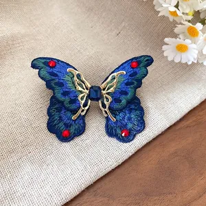 Elegante anello a farfalla ricamato blu con strass scintillanti.