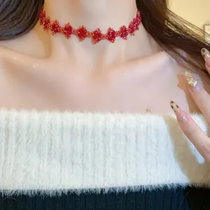 Detail view of red beaded floral choker necklace worn on model's neck