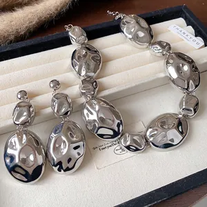 Detailed view of silver hammered oval link necklace and matching drop earrings jewelry set