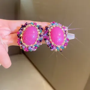 Detailed macro view of vintage luxury earrings with hot pink stone and colorful beads
