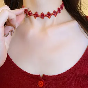 Exquisite close-up of a handmade red beaded flower choker necklace worn on a neck.