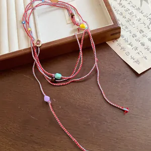 Detailed view of handmade woven cord waist chain decorated with colorful bead accents