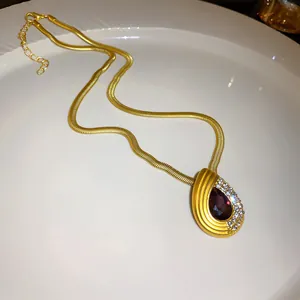 Gros plan d'un collier vintage doré avec pendentif en forme de goutte d'eau