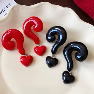 Close-up detail view of creative question mark heart earrings in red and black resin.