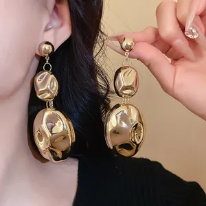 Detailed close-up showing the metallic crumpled texture of gold chunky oval drop earrings