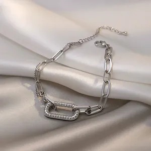 Close-up of a silver-toned geometric bracelet with pavé rhinestones on white satin fabric