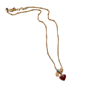 Elegant 18k gold plated necklace featuring a red enamel heart pendant with charms