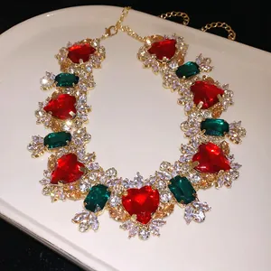 Dettaglio macro di collana vintage con cuori rossi e zirconi verdi taglio smeraldo