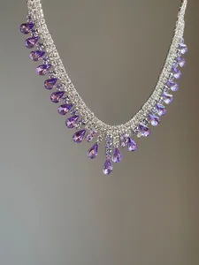 Detailed macro view of purple waterdrop crystal fringe on elegant silver necklace