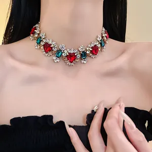 Dettaglio della collana girocollo vintage con zirconi a cuore e pietre rosse e verdi su modella